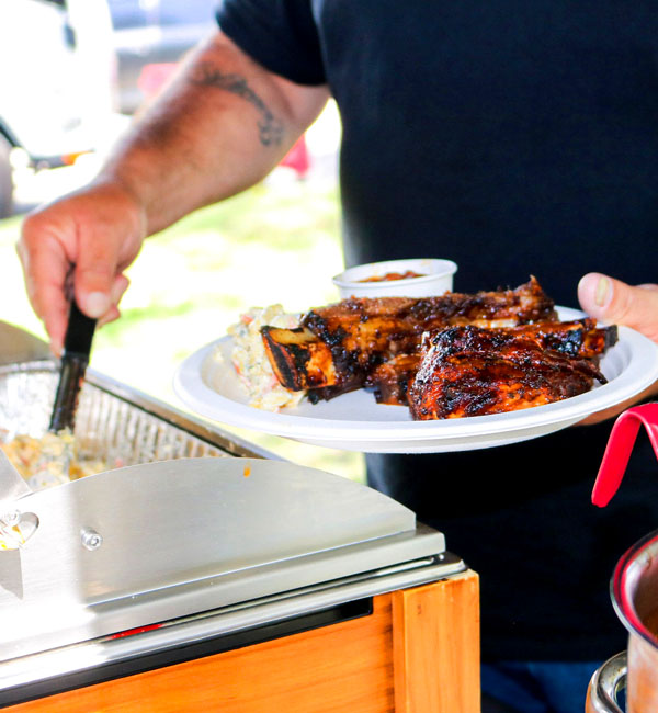 Man serving himself some barbecue ribs, catering services