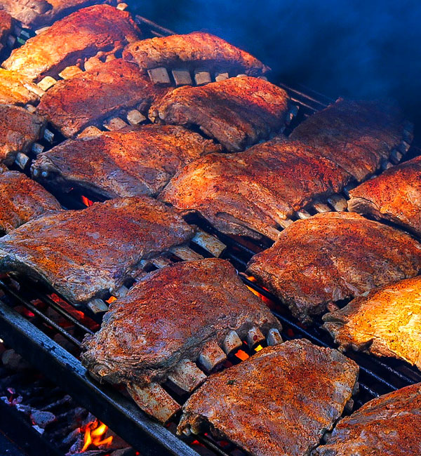 Ribs cooking on grill, mobile catering